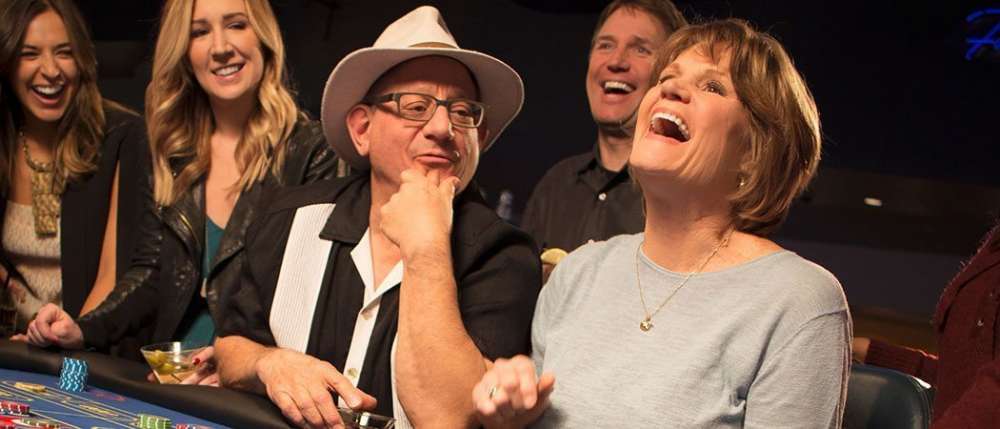 Friends laughing at a blackjack table