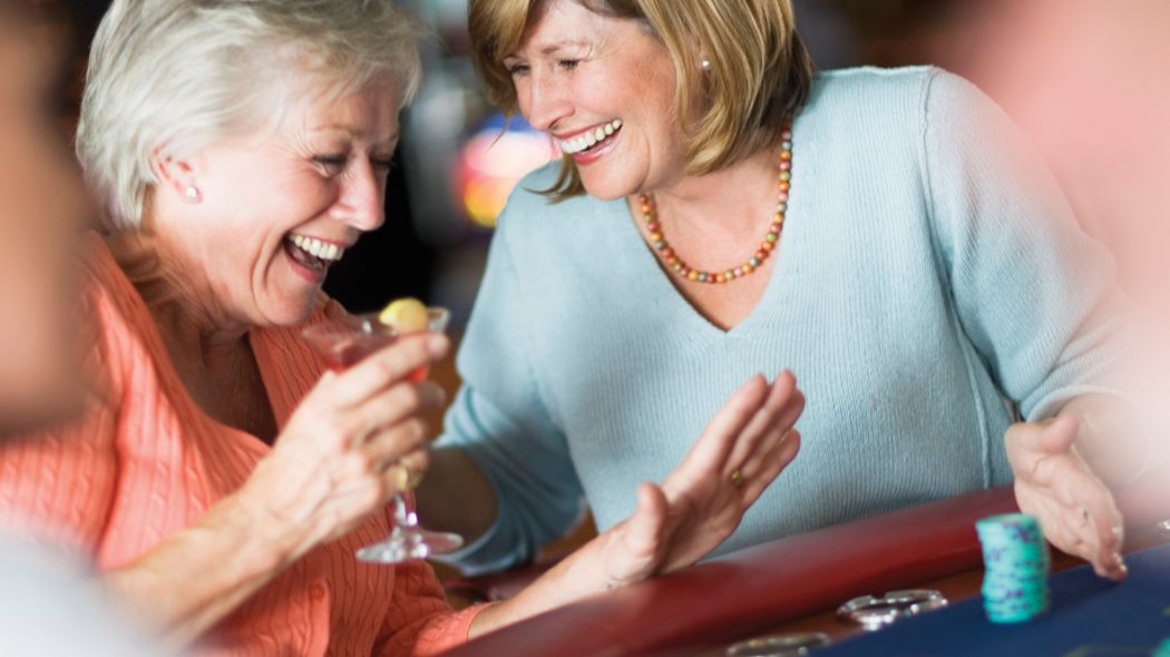 Image of two women laughing at a poker table