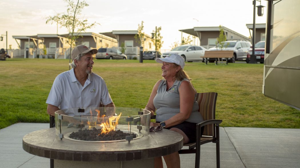 A couple sitting around a fire pit